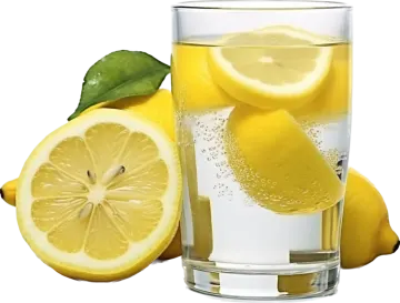 a glass of lemon water next to sliced lemons