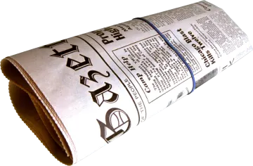 a roll of newspaper sitting on a white surface