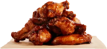 a pile of chicken wings with sauce on top