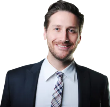 a man in a suit and tie smiles at the camera