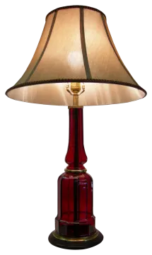 a red table lamp with a beige shade
