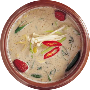 a brown bowl filled with soup and vegetables