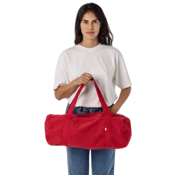 a woman holding a red duff bag
