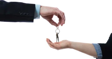 a person handing a key to another person