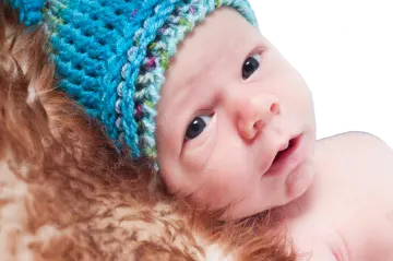 a close up of a baby wearing a hat