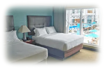 two beds in a hotel room with large windows