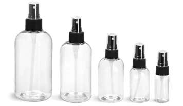a set of four clear bottles with black caps