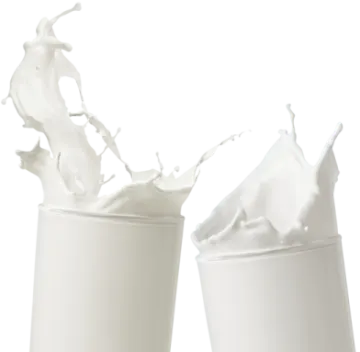 two cups with milk splashing out of them