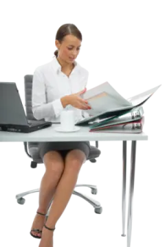 a woman sitting at a desk with a laptop and papers