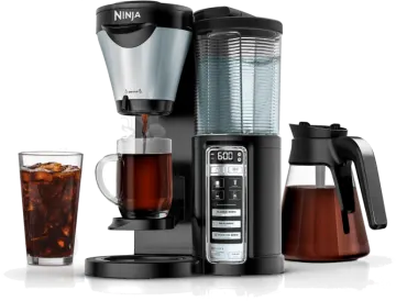 a black and silver coffee maker next to a glass