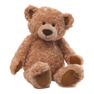 a brown teddy bear sitting on a white surface