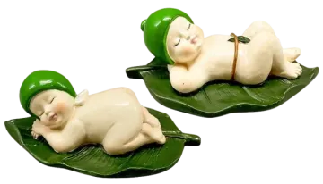 two small figs of a baby sleeping on a leaf