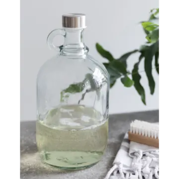 a bottle filled with green liquid next to a brush