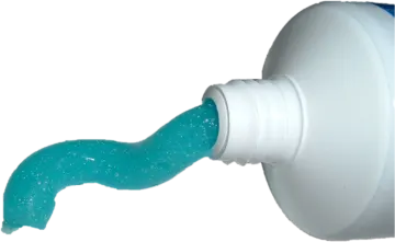 a bottle filled with blue liquid next to a white wall