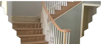 a staircase with white railing and wood handrail