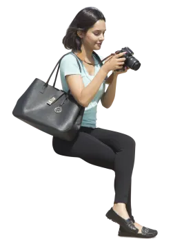 a woman sitting on the ground holding a camera
