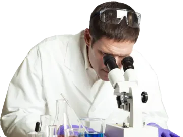 a man in a lab coat looking through a microscope