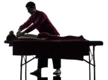 a man is sitting on a massage table