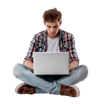 a young man sitting on the floor using a laptop