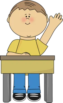 a boy sitting at a desk with his hand up
