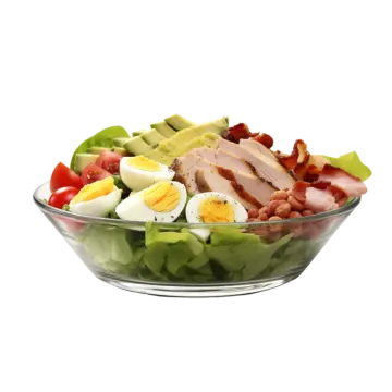 a salad with bacon, eggs and tomatoes in it
