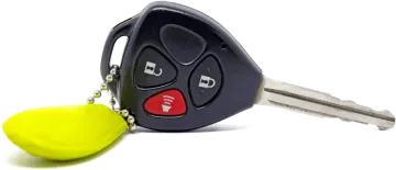 a car key with a yellow ball attached to it