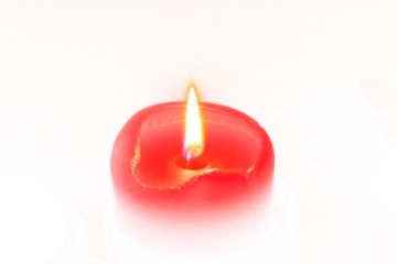 a red candle sitting on top of a table