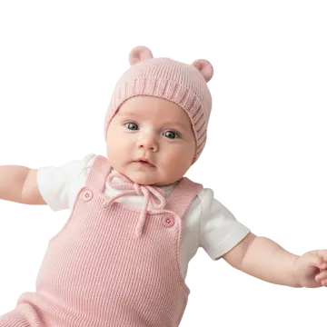 a baby wearing a pink knitted hat and overall