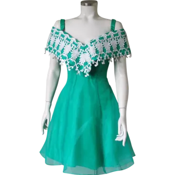 a green dress with white lace on the shoulders