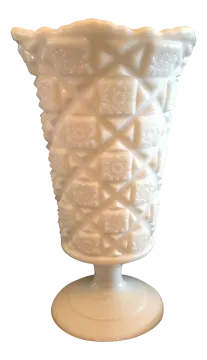 a white vase sitting on top of a table