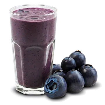 a glass of blueberry smoothie next to some blueberries
