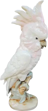 a white parrot sitting on top of a tree stump