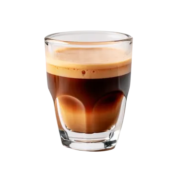 a glass filled with coffee sitting on top of a table