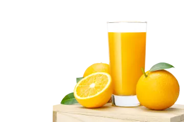 a glass of orange juice next to two oranges