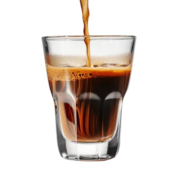 a glass filled with coffee being poured into it
