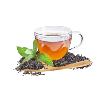 a glass cup filled with black tea and mint leaves