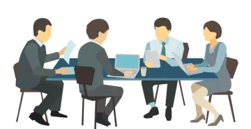 a group of people sitting at a table with laptops