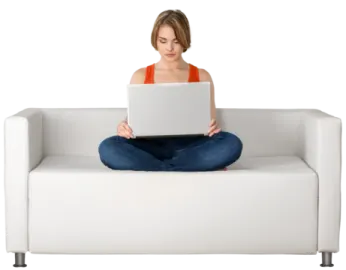 a woman sitting on a couch using a laptop