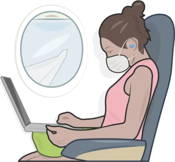 a woman sitting in an airplane with her laptop