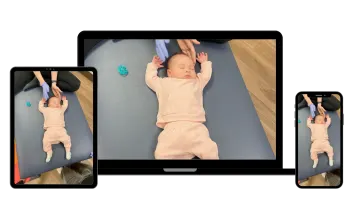 a baby laying on the floor in front of two ipads