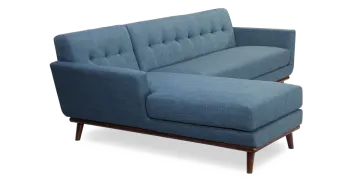 a blue sofa with dark wood legs