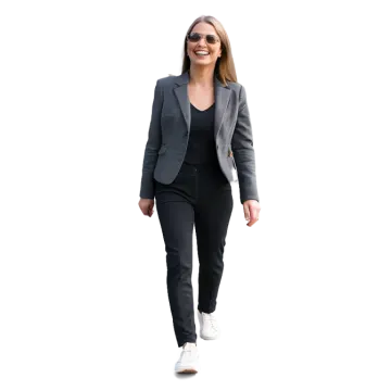 a woman wearing a grey suit and white sneakers
