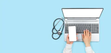 a person typing on a laptop with a stel