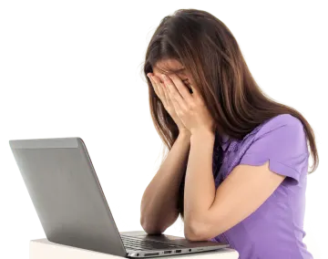 a woman with her head in her hands while looking at her laptop