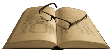 an open book with glasses on top