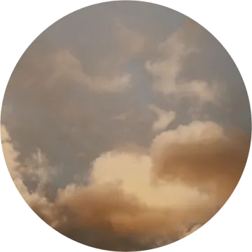 a circle with clouds in the sky