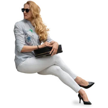 a woman sitting on the ground holding a purse