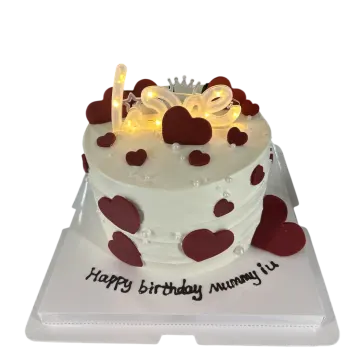 a white cake with red hearts on top