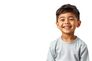 a young boy smiling with his hands in his pockets