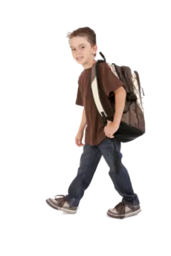 a young boy walking with a backpack on his back
